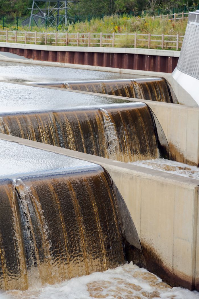 About A weir with flowing water showcasing modern engineering outdoors.