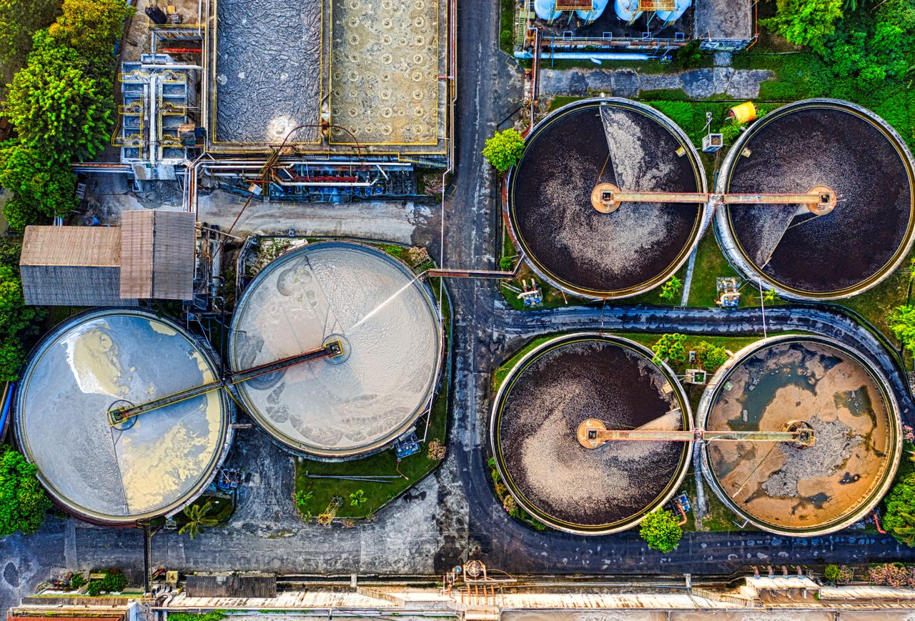 About Top-down view of a water treatment plant in an industrial area of Indonesia.